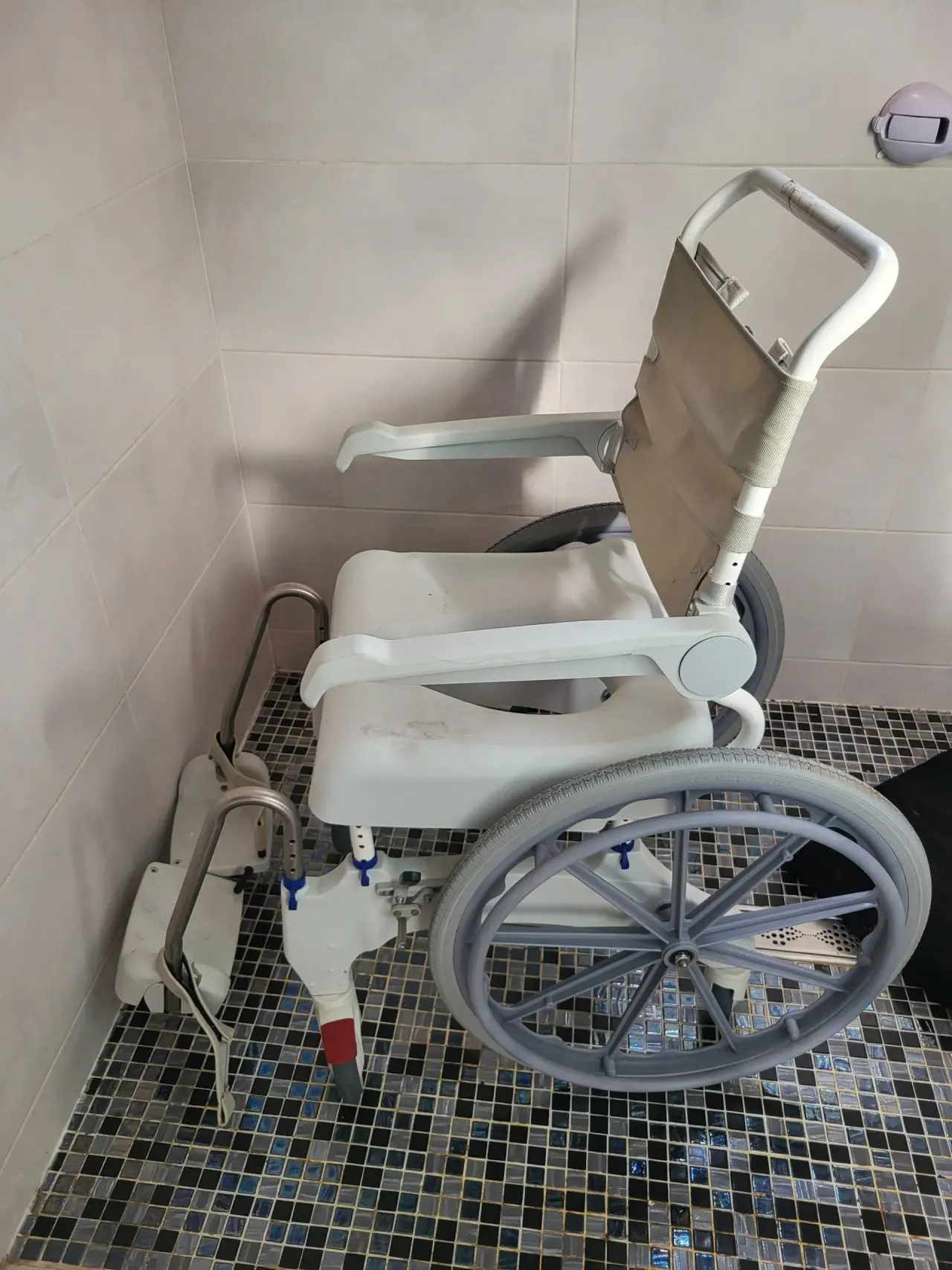 Fauteuil roulant de douche et toilettes gris clair et beige, en plastique et textile, usagé avec