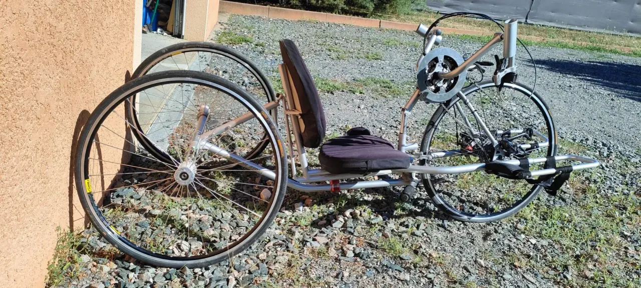 Tricycle couché argenté en aluminium et tissu, en très bon état, doté d'un siège ergonom