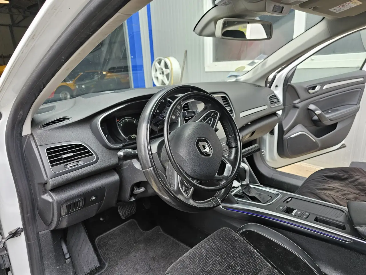Intérieur de voiture Renault noir/gris en plastique, tissu et cuir, en bon état général avec légères traces