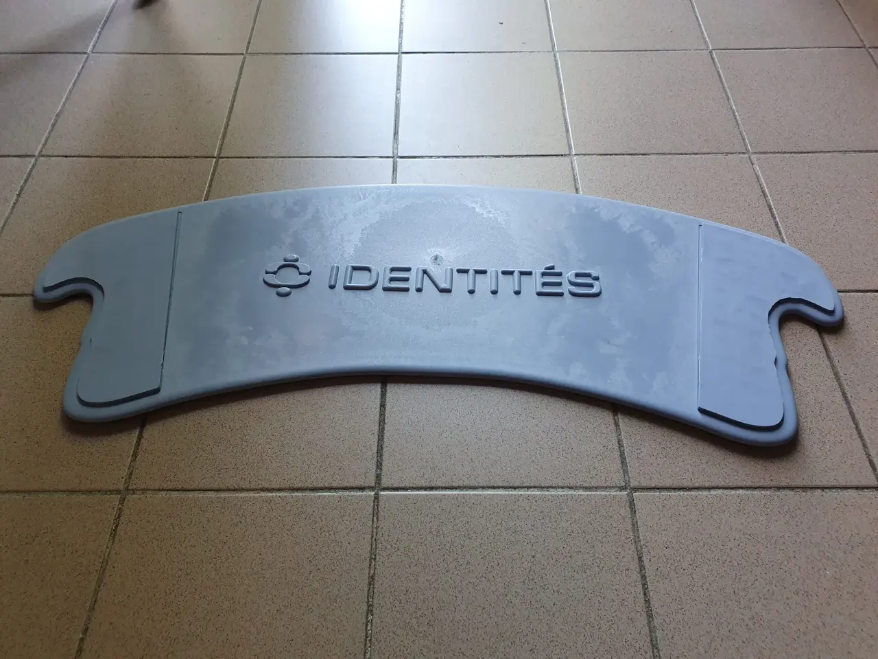 Planche de transfert incurvée gris clair en plastique, avec poignées latérales découpées, en état d'