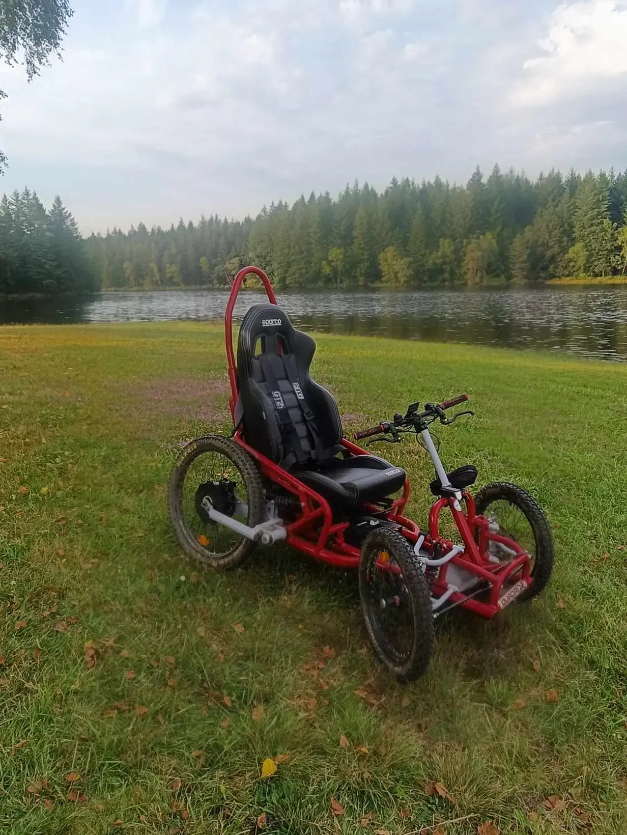 Quadricycle tout-terrain électrique rouge avec siège baquet Sparco noir, cadre métallique, pneus crant