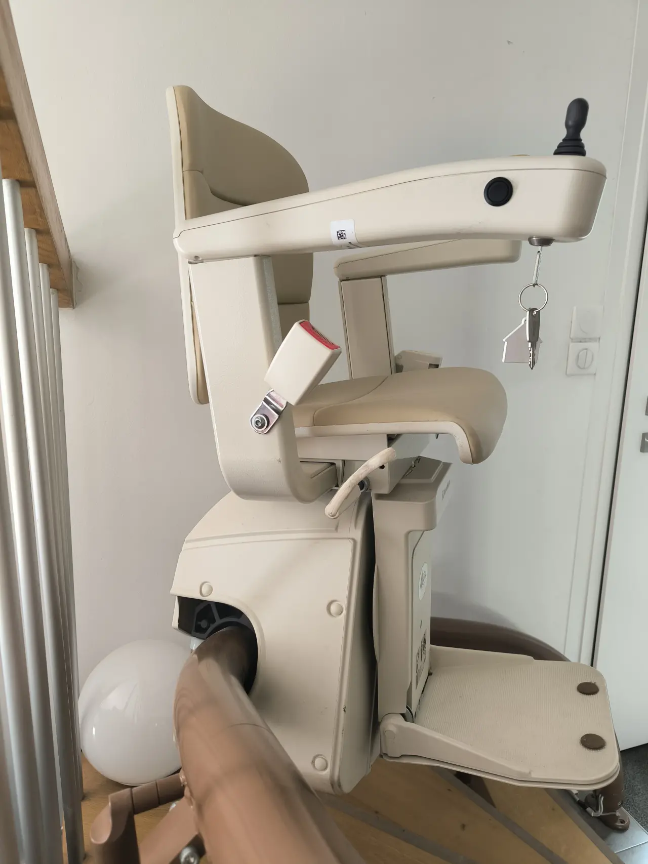 Monte-escalier motorisé beige clair en plastique et similicuir, en bon état général, équipé d'un joystick, d'une