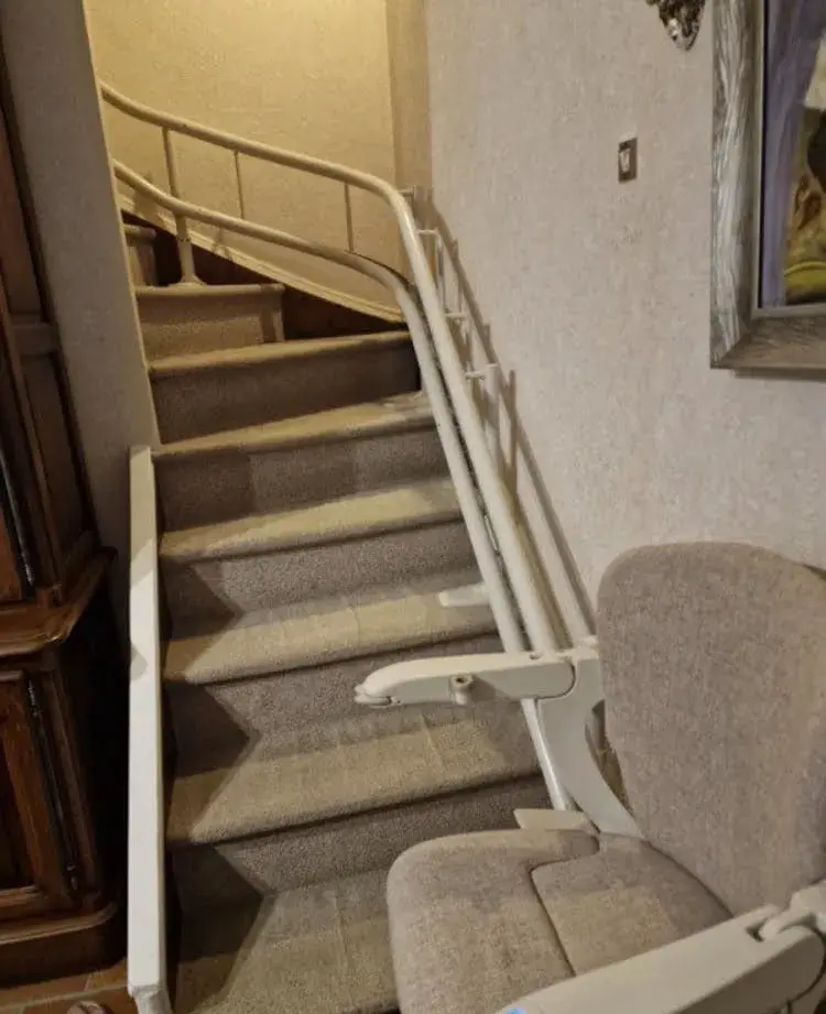 Monte-escalier à siège beige clair, en métal et tissu, en excellent état, sur rail courbe pour escal