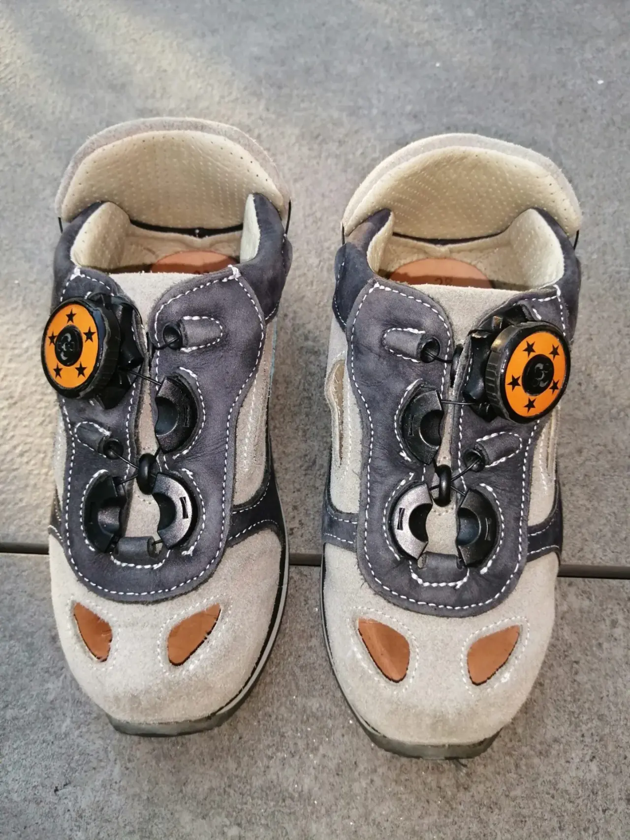 Chaussures enfant en daim bicolore gris clair et foncé, bon état, avec système de serrage rotatif orange à étoiles