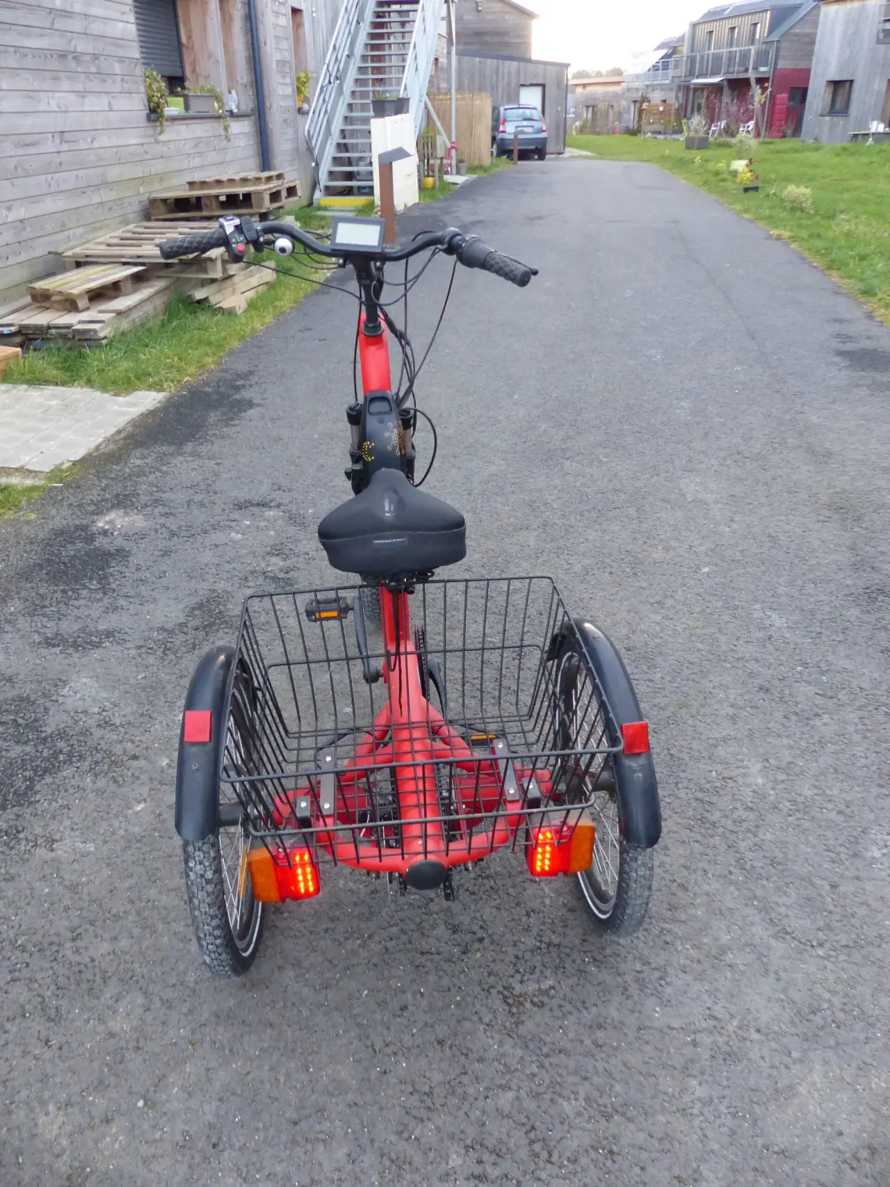 Tricycle électrique rouge en métal et plastique, en excellent état, avec un grand panier arrière et un