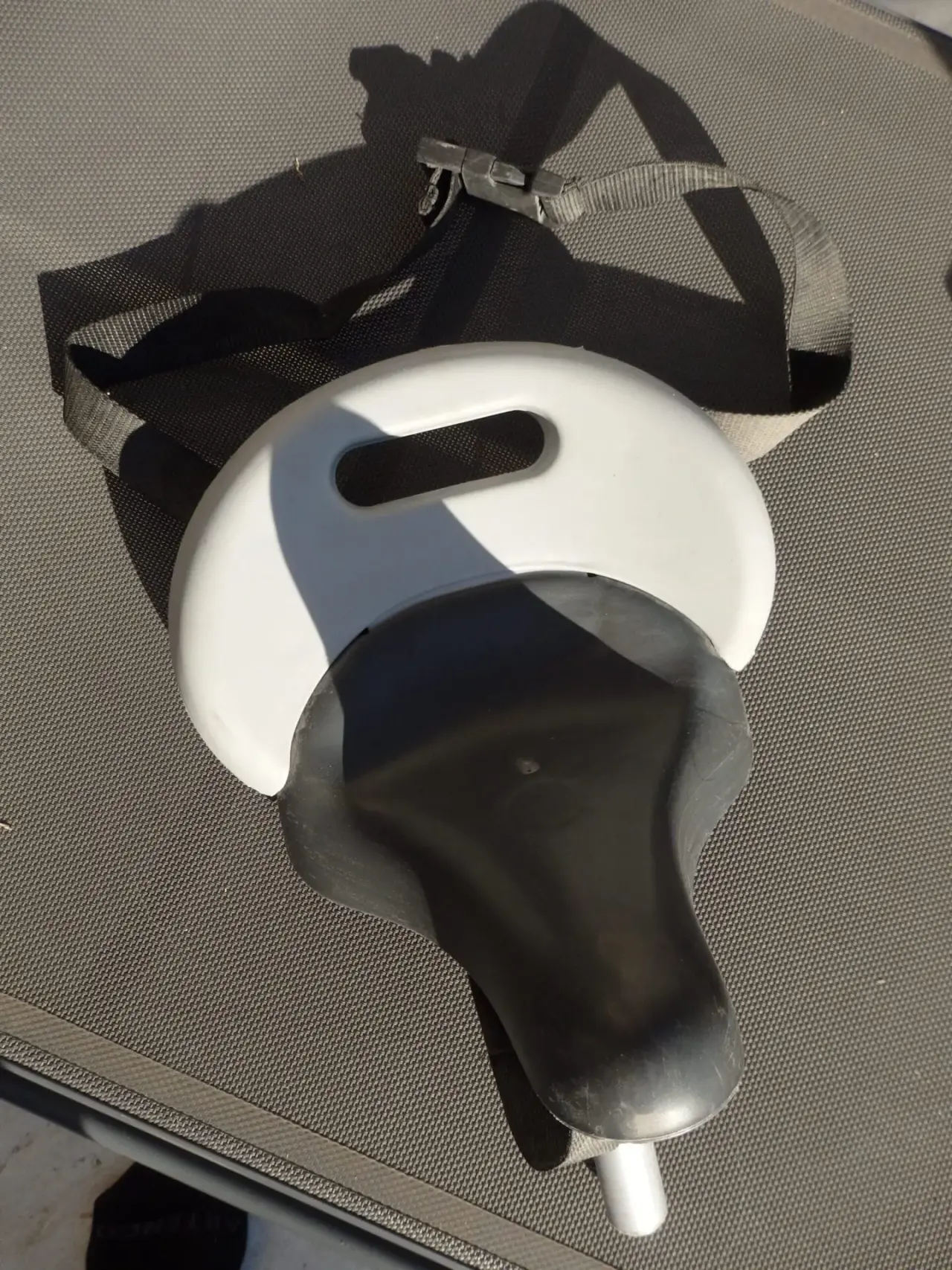 Siège de vélo enfant noir en plastique et tissu, avec dossier blanc intégré et sangle réglable, en bon état général