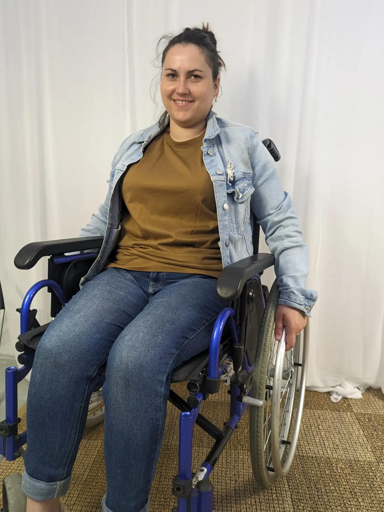Fauteuil roulant manuel à structure métallique bleu vif, accoudoirs et assise noirs, roues