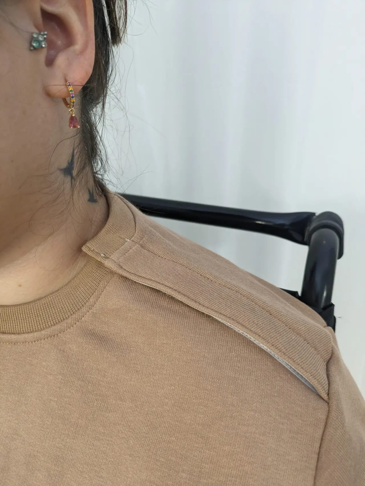Un pull en molleton de coton beige clair à col rond côtelé, d'apparence neuve et douce, présente un détail de couture horizontale renforc