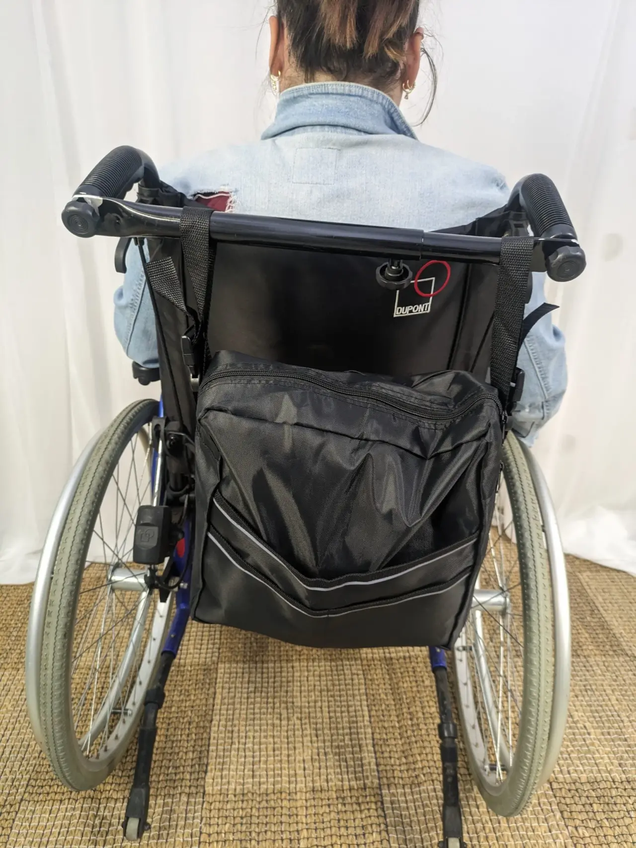 Fauteuil roulant manuel noir et bleu, en métal et tissu, avec pneus gris, doté d'une sacoche arrière intégrée et d'un dossier logoté DUPONT, en excellent état