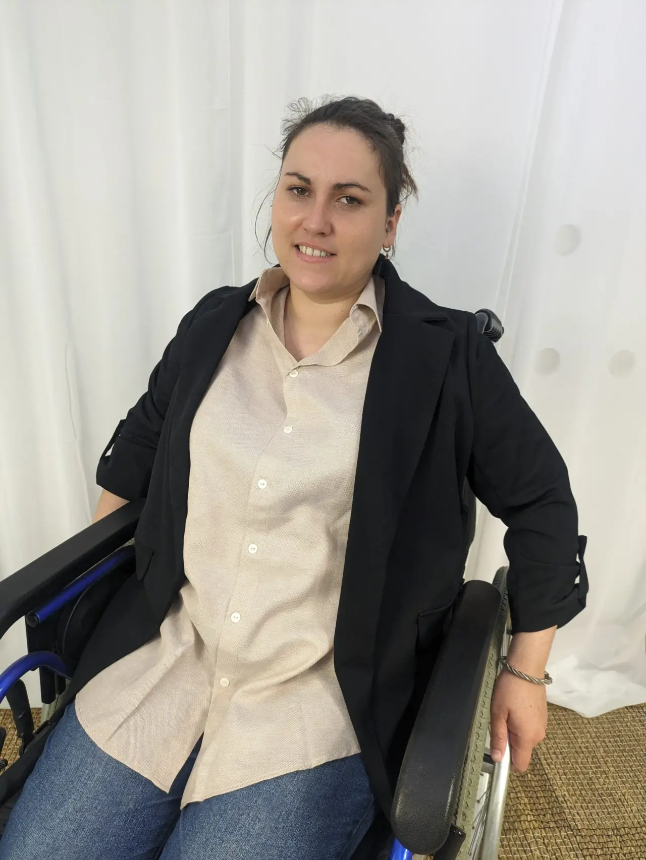 Veste blazer noire en tissu fluide, manches retroussées à attaches, portée sur une chemise beige en lin texturé, en excellent état