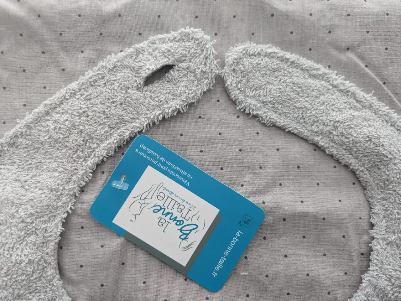 Bavoir gris clair en tissu éponge neuf, doté d'une ouverture pour le cou et d'une ét