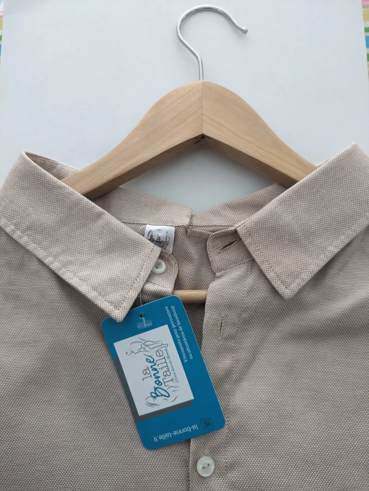 Polo beige en coton piqué, neuf avec son étiquette bleue "La Bonne Taille" visible, boutons clairs