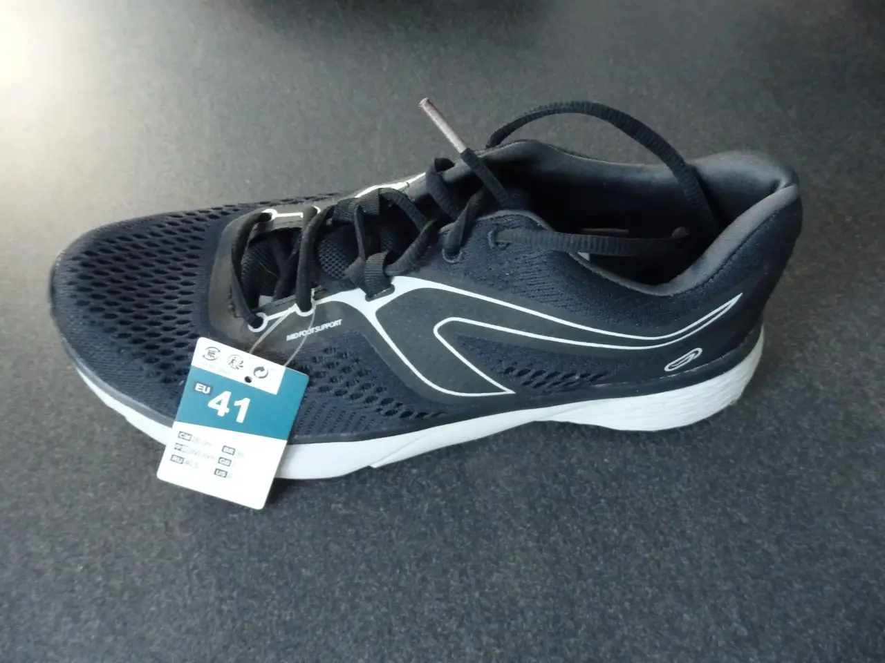 Chaussure de running neuve, bleu marine en mesh et synthétique, semelle blanche, accents latéraux blancs, étiquette taille EU 41